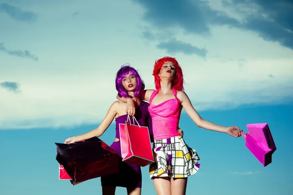 Girls with artificial hair with colorful shopping bag. — Stock Photo, Image