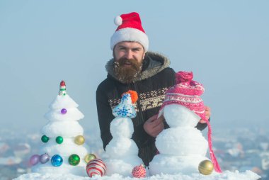 Kar xmas ağacı ve heykeller üzerinde mavi gökyüzü