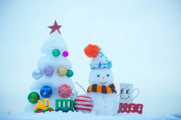Christmas tree with decorations, toy train, cup and present box — Stock Photo, Image