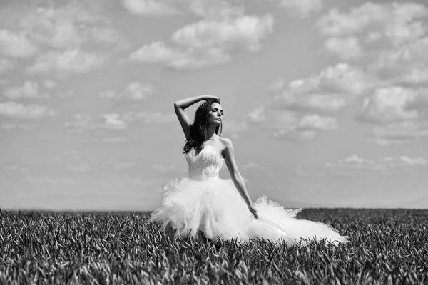 Hübsches Hochzeitsmädchen auf grünem Gras und Himmel — Stockfoto