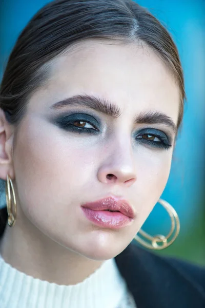 Chica o mujer con maquillaje en la cara de desgaste pendientes de oro —  Fotos de Stock