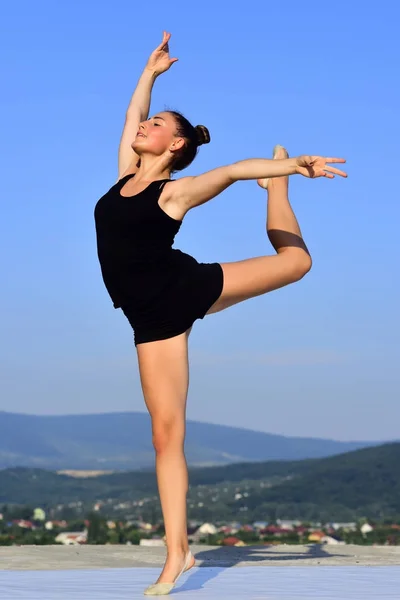 Kvinna gymnast i svart sportkläder i yoga posera. — Stockfoto