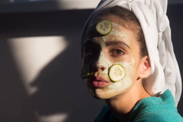 Flicka eller kvinna ansikte med gurka mask, handduk på huvudet — Stockfoto
