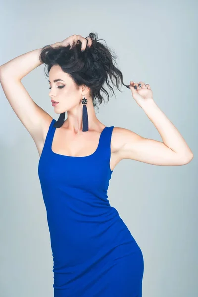 Дівчина з макіяжем у блакитній сукні на сірому фоні — стокове фото