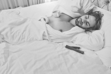 sakallı adam yatakta uzaktan kumandalı