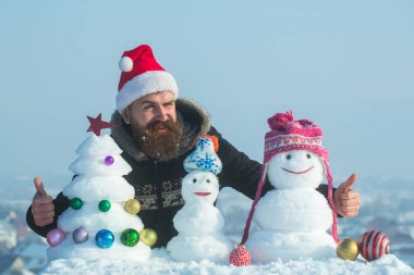 Noel Baba adam ile karlı heykeller göz kırpıyor