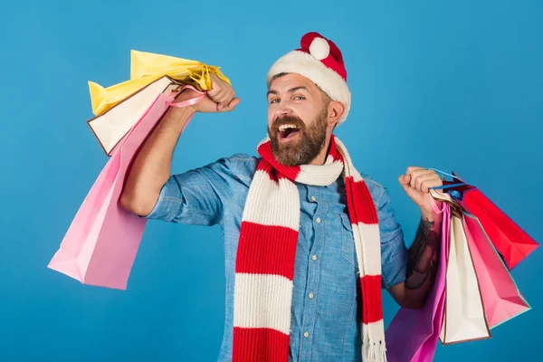 サンタの帽子とマフラーでクリスマス男の買い物客の幸せな笑顔します。 — ストック写真