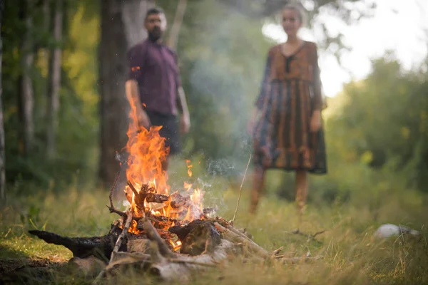 Мужчина и женщина на размытом фоне смотрят на пламя огня — стоковое фото