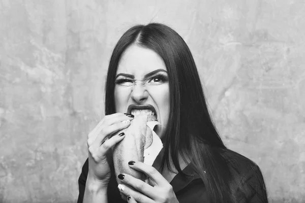 Sexy pretty brunette aggressive woman eats big sandwich or burge — Stock Photo, Image