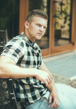 Ekose gömlekli adam bankta oturmak