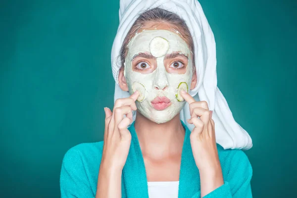 Meisje gezicht met kus lippen, komkommer masker op groene achtergrond — Stockfoto