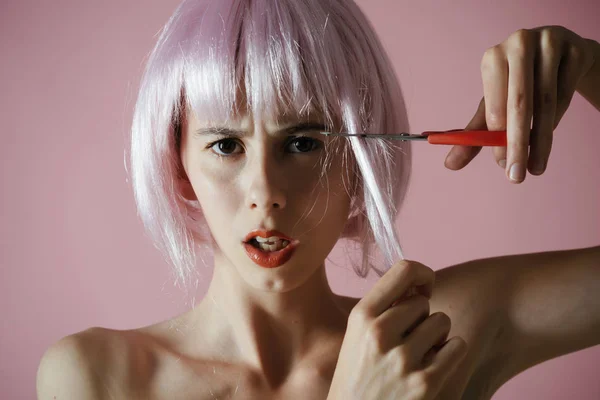 Meisje knippen kunstmatige haar met een schaar. — Stockfoto
