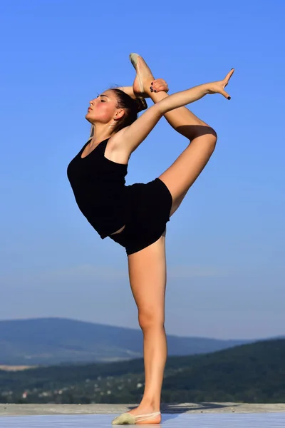 Kvinna gymnast i svart sportkläder i yoga posera. — Stockfoto