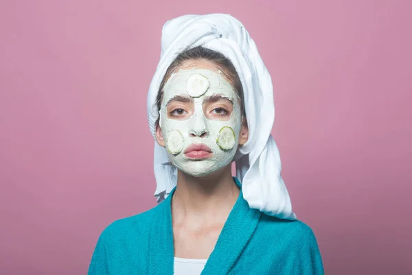 Femme visage avec masque de concombre sur fond violet — Photo