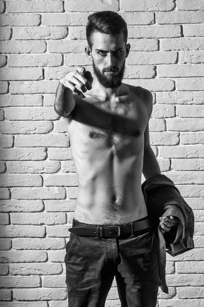 Стройный бородатый мужчина с тонким туловищем на кирпичном фоне — стоковое фото