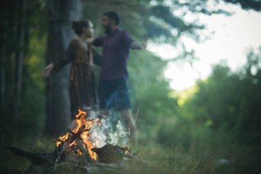 Kamp ateşi, bulanık arka plan üzerinde çift aşık sarılmak