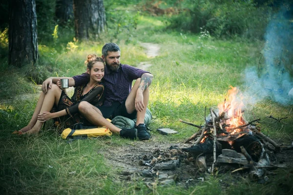 Casal apaixonado olhar para fogueira em madeira — Fotografia de Stock