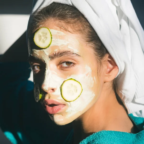 Девушка или женщина лицо с огуречной маской, полотенце на голове — стоковое фото