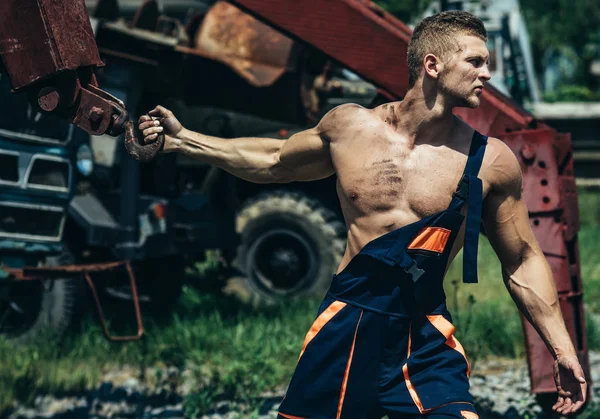 Bodybuilder met spier borst, handen, biceps, triceps trekken ijzeren kraan — Stockfoto