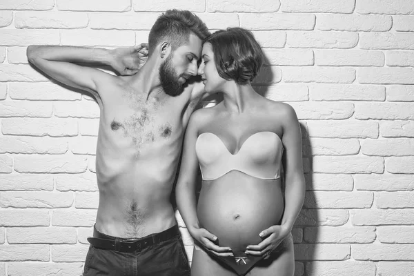 Bearded slim man and pretty pregnant woman with round belly — Stock Photo, Image