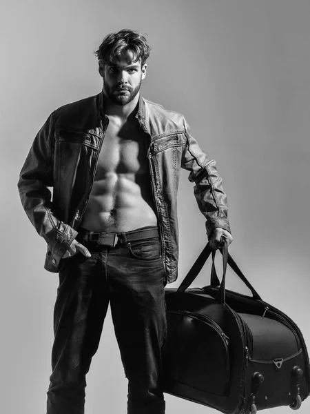 Muscular bearded man with sexy body holds big bag, suitcase — Stock Photo, Image