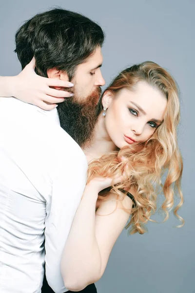Casal apaixonado com moderno penteado abraço no fundo cinza — Fotografia de Stock