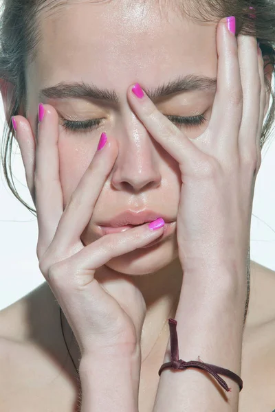 Chica con los ojos cerrados tocar la cara con dedos de uñas de color rosa —  Fotos de Stock