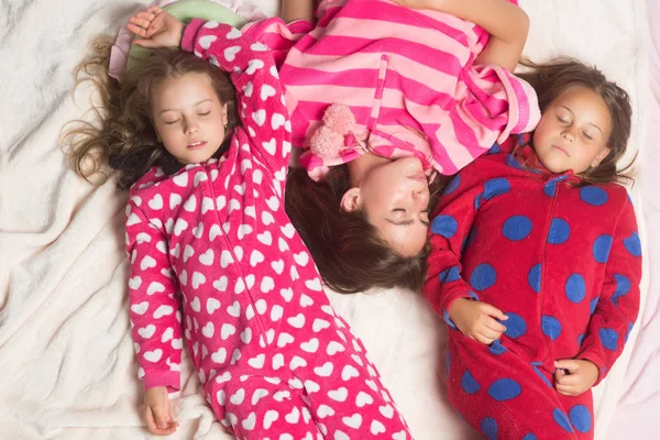 Сестры или друзья в пижаме спят в кровати, вид сверху — стоковое фото