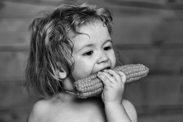 Engraçado menino pequeno criança comendo milho amarelo — Fotografia de Stock