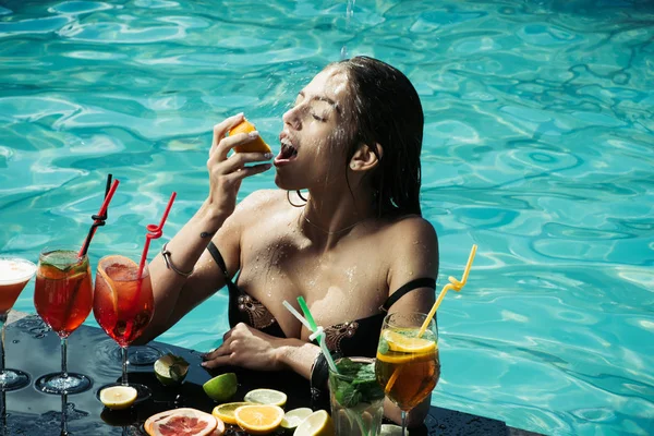 Meisje in pool met cocktail en vruchten op zomervakantie — Stockfoto