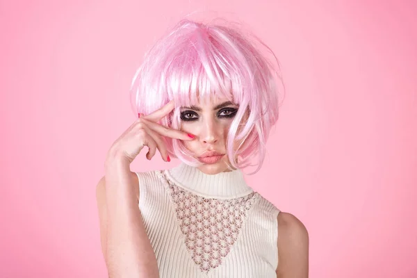 Kobieta nosić różowe perukę włosów na różowe tło — Zdjęcie stockowe
