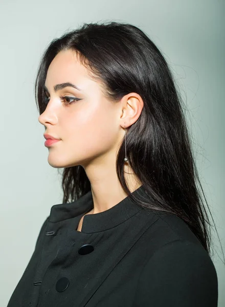 Menina com rosto de maquiagem em vestido preto no fundo cinza — Fotografia de Stock