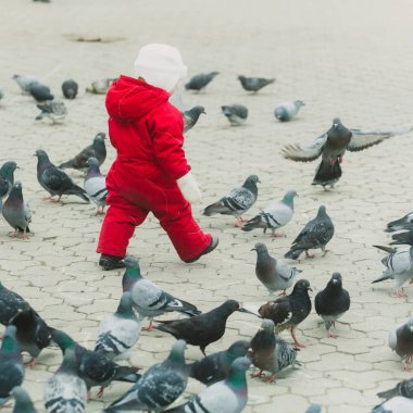 Kırmızı sıcak genel olarak güvercinler ile yürüyen çocuk
