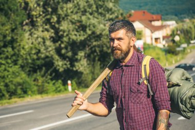 Sakallı adam uzun yürüyüşe çıkan kimse tutun balta ve yolda sırt çantası