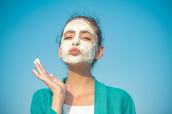 Vrouw stuurt lucht kus met cosmetische masker op gezicht — Stockfoto