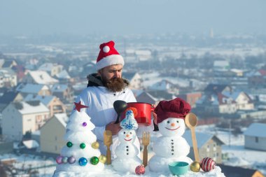 Yemek, kardan adam ve xmas ağacı üzerinde mavi gökyüzü kar