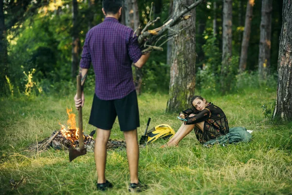 Homem com monte de lenha e machado olhar para a mulher — Fotografia de Stock