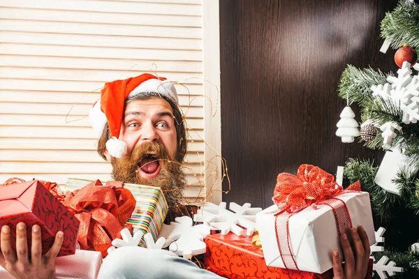 Weihnachtsmann mit Geschenkschachtel am Weihnachtsbaum. — Stockfoto