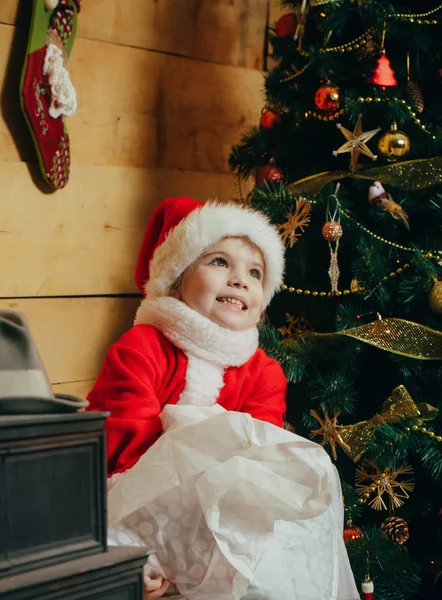 Santa claus kid på julgran. Xmas party fest. Nytt år liten flicka i hatt. Sportlovet och semester. Christmas lyckligt barn med ??????? ????? — Stockfoto