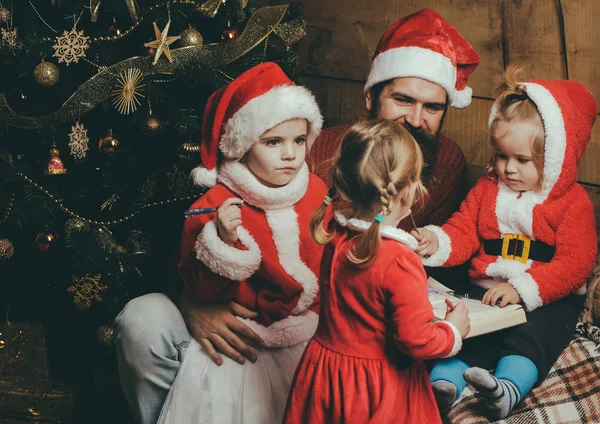 Weihnachtsglückliche Kinder und Vater lesen Buch. — Stockfoto