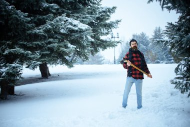 Kar kış ormanı içinde sakallı adam tutun balta.