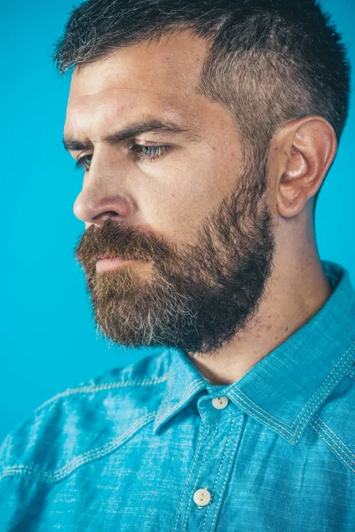 Борода на серйозній людині в джинсовій сорочці на синьому фоні — стокове фото