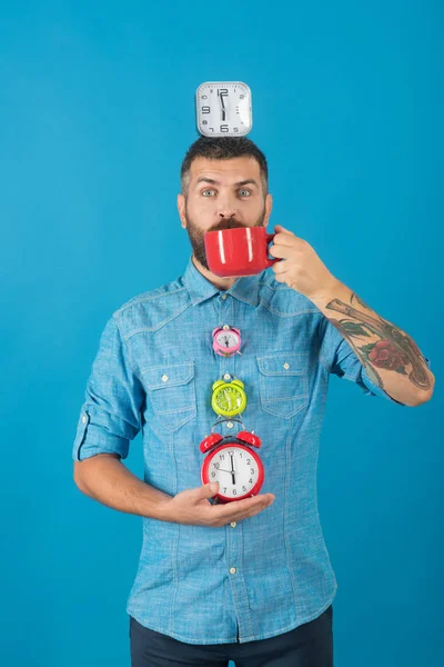 Happy guy avec vin chaud, horloge sur fond bleu . — Photo