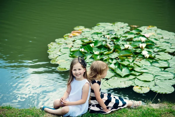 Дівчата Сидять Траві Біля Ставка Квітами Водяної Лілії Діти Щасливі — стокове фото