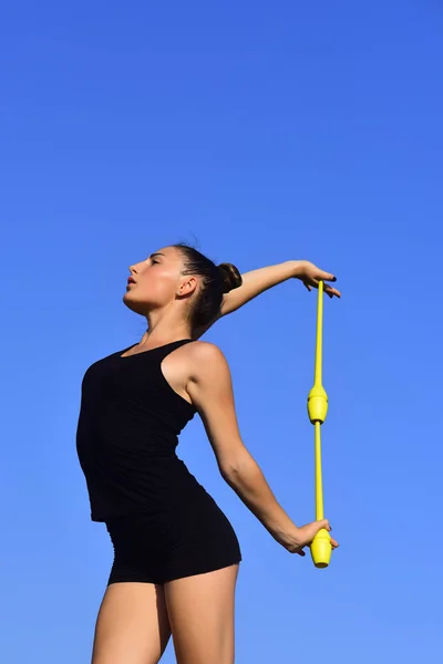 Kvinna gymnast i svart sportkläder med gröna mace. — Stockfoto