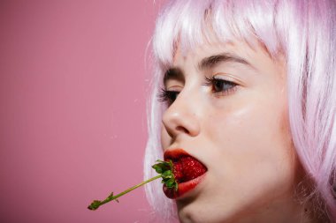 Kız yapay saç tutun kırmızı dut ağzına.