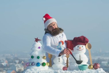 Mavi gökyüzü mutsuz aşçı, kardan adam ve kar xmas ağacı