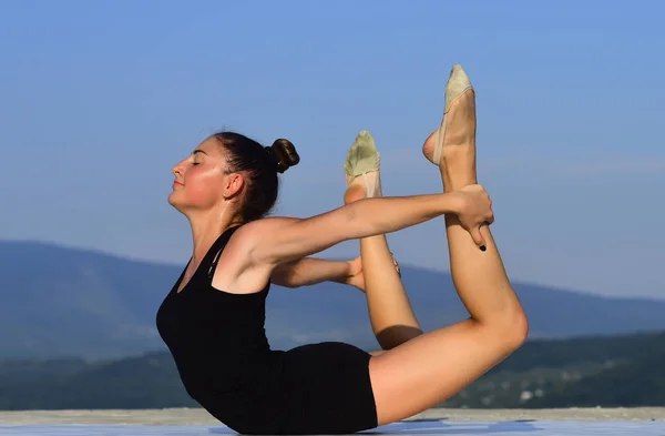 Pilates träning av flicka på blå himmel bakgrund. — Stockfoto