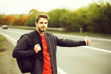 Genç adam otostop çekiyor.