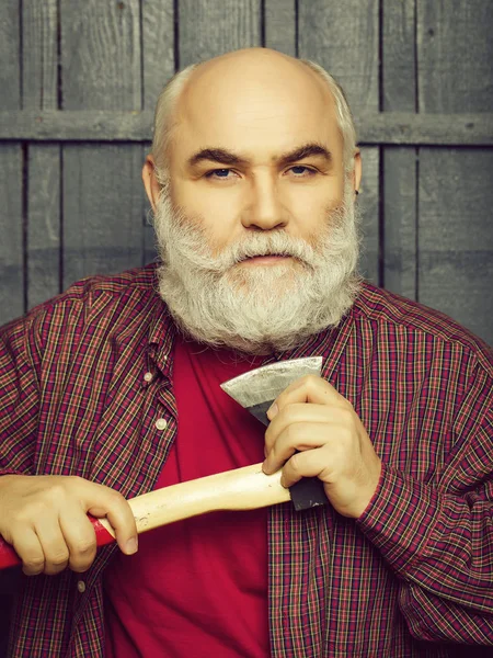 Old man shaving with axe